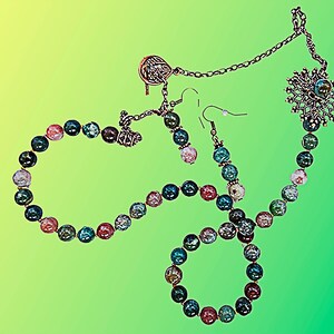 May include: A jewelry set featuring a necklace, bracelet, and earrings. The necklace and bracelet are made of colorful, round beads in shades of blue, pink, and green. The earrings have matching beads. The set includes silver-toned metal accents.