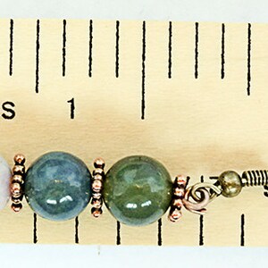 May include: A single earring featuring a light pink, blue-green, and green bead design. The beads are separated by copper-colored spacers and attached to a metal ear wire. The earring is approximately 1 inch in length.