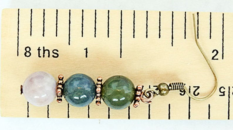 May include: A single earring featuring a light pink, blue-green, and green bead design. The beads are separated by copper-colored spacers and attached to a metal ear wire. The earring is approximately 1 inch in length.