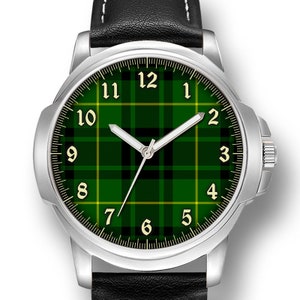 May include: A silver watch with a black leather strap. The watch face has a green and black tartan pattern with white numbers.