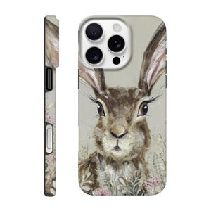 May include: A phone case featuring a detailed painting of a brown rabbit with long ears and expressive eyes. The artwork includes subtle floral accents and a neutral background, creating a nature-inspired design. The case is shown from the front and side.