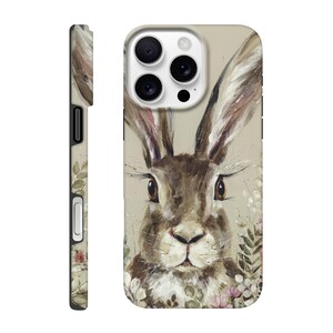 May include: A phone case featuring a watercolor painting of a brown rabbit with long ears and detailed eyes. The design includes floral accents in pink and white, set against a neutral background. The side view shows a complementary floral pattern.