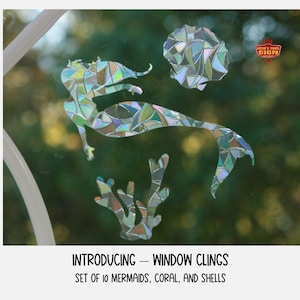 May include: A set of 10 iridescent window clings featuring mermaids, coral, and seashells. The clings are made of a mosaic-like material and have a shimmering effect.