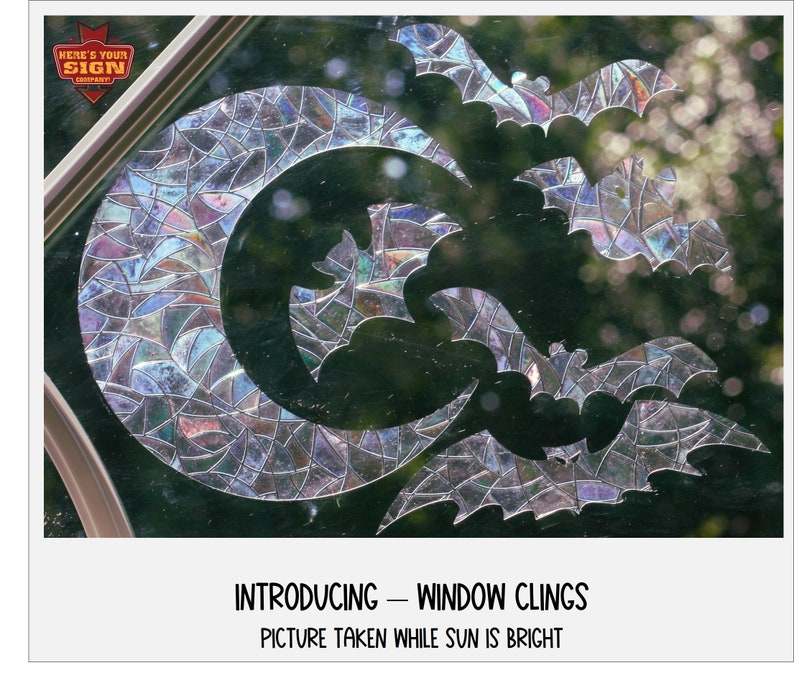 May include: A set of iridescent window clings featuring a crescent moon and bats. The clings are designed to be placed on a window and are visible from the outside. The image shows the clings on a window with a bright sun shining through. The text "Introducing - Window Clings" and "Picture taken while sun is bright" is visible at the bottom of the image.