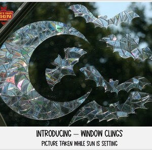 May include: A set of iridescent window clings featuring a crescent moon and bats. The clings are designed to look like stained glass. The image is captioned "Introducing - Window Clings. Picture taken while sun is setting."