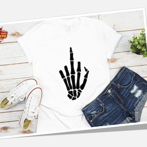 May include: White t-shirt with a black skeleton hand giving the middle finger.