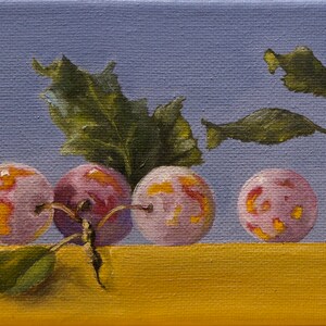 May include: A painting of seven plums with yellow and pink skin, arranged in a row on a yellow surface. The plums are surrounded by green leaves.