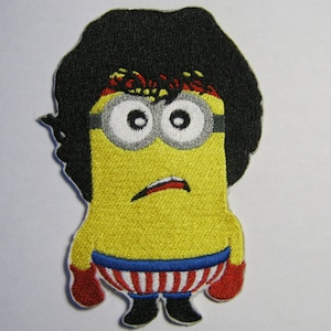 Könnte beinhalten: Eine gelbe Minion-Cartoonfigur mit schwarzen Haaren, die rote Boxhandschuhe und eine rot-weiß gestreifte Boxuniform trägt.