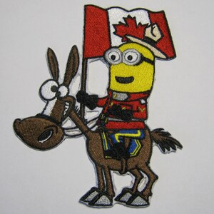 May include: An embroidered patch featuring a yellow minion wearing a red and blue uniform and a Canadian flag hat, riding a brown donkey.