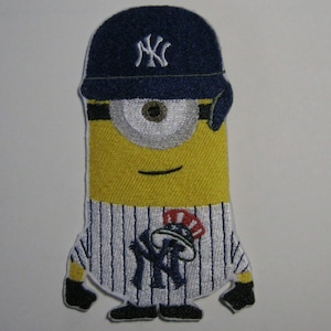 May include: A yellow minion wearing a blue and white striped baseball uniform with a blue baseball cap with a white "NY" logo. The minion is wearing a red, white and blue hat with a white "NY" logo on top of the baseball cap.