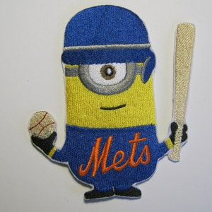 Op de afbeelding: Een geborduurde patch van een minion die een baseballpet draagt, een knuppel en een honkbal vasthoudt. De minion draagt ​​een blauw shirt met het woord "Mets" in oranje.
