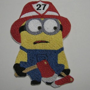 Può includere: Un minion giallo che indossa un cappello da pompiere rosso con il numero 27. Il minion tiene un'ascia e ha un'espressione preoccupata sul viso.