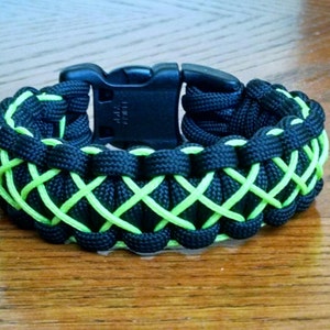May include: A black and lime green paracord bracelet with a black plastic buckle.