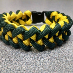 May include: A green and yellow paracord bracelet with a black plastic buckle.