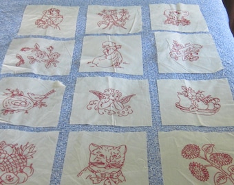 Op de afbeelding: Twaalf vierkante witte stoffen lapjes met rood borduurwerk van een kind, bloemen, een hond, een vogel in een nest, een engel, een schaal met fruit, een kat en zonnebloemen. Eén lapje bevat de tekst MY REDWORK.