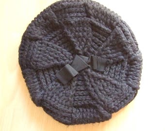 May include: A black knitted beret with a large black bow.