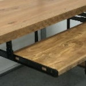 Op de afbeelding: Een houten bureau met een zwart metalen frame en een uittrekbare plank. Het bureau heeft een natuurlijke houten afwerking en een rustieke uitstraling.
