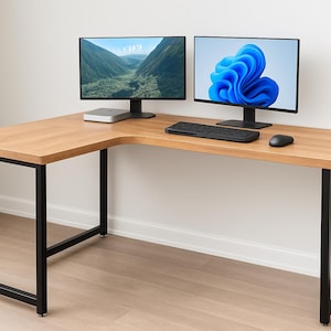 May include: L-shaped wooden desk with black metal legs. Two computer monitors display images. A keyboard, mouse, and small computer are on the desk. The desk is in a room with a window and white walls.
