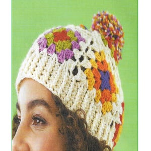 May include: A crochet pattern for a Granny Square Hat. The hat is cream-coloured with colourful squares in orange, yellow, purple, and green. A multi-coloured pom-pom sits atop the hat. The text "Granny Square Hat Crochet Pattern" and "CA116" are visible.