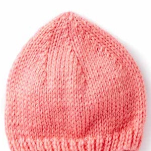 Puede incluir: Un gorro de bebé de punto rosa. El gorro está hecho con un patrón de punto sencillo y tiene un borde enrollado. El gorro está etiquetado con el número 267.