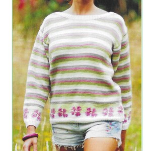 May include: A striped and floral knit jumper with a white, green, pink, and grey colour scheme. The jumper has a round neckline and long sleeves. The bottom of the jumper has a row of pink flowers. The jumper is labelled with the number K481.