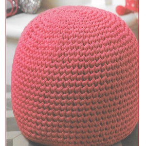 Peut inclure: Un pouf en crochet rose, un repose-pieds ou un ottoman rond et moelleux, avec une surface texturée. Le pouf est sur un sol carrelé. L'image comprend également le texte "H123".
