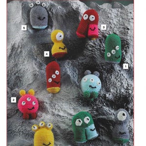 May include: A crochet pattern for making 8 different alien characters. The aliens are all different colours and have different facial expressions. The pattern is called "Little Aliens Crochet Pattern" and is numbered T32.