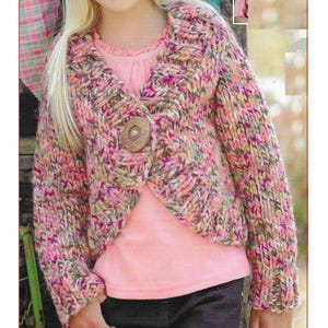 May include: A multi-colored knitted cardigan with a single button closure. The cardigan is a cropped style and has long sleeves. The cardigan is shown on a young girl wearing a pink shirt and black pants. The image also includes the text "C223".