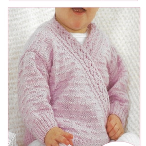 May include: A light pink, knitted baby cardigan with a wrap-style design. The cardigan features a textured stitch pattern and a decorative border along the neckline. The text "Crossover Cardigan Knitting Pattern" is at the top.