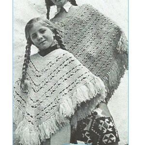 May include: Two girls wearing crocheted ponchos with fringe. The ponchos are white and have a lacy pattern. The image is in black and white and has the text "CC21" at the bottom.