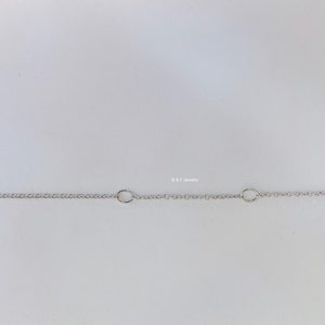 May include: A silver chain necklace with a lobster clasp fastening. The chain has two jump rings.
