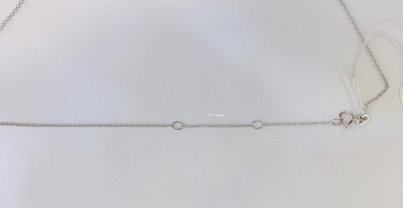 May include: A silver chain necklace with a lobster clasp fastening. The chain has two jump rings.