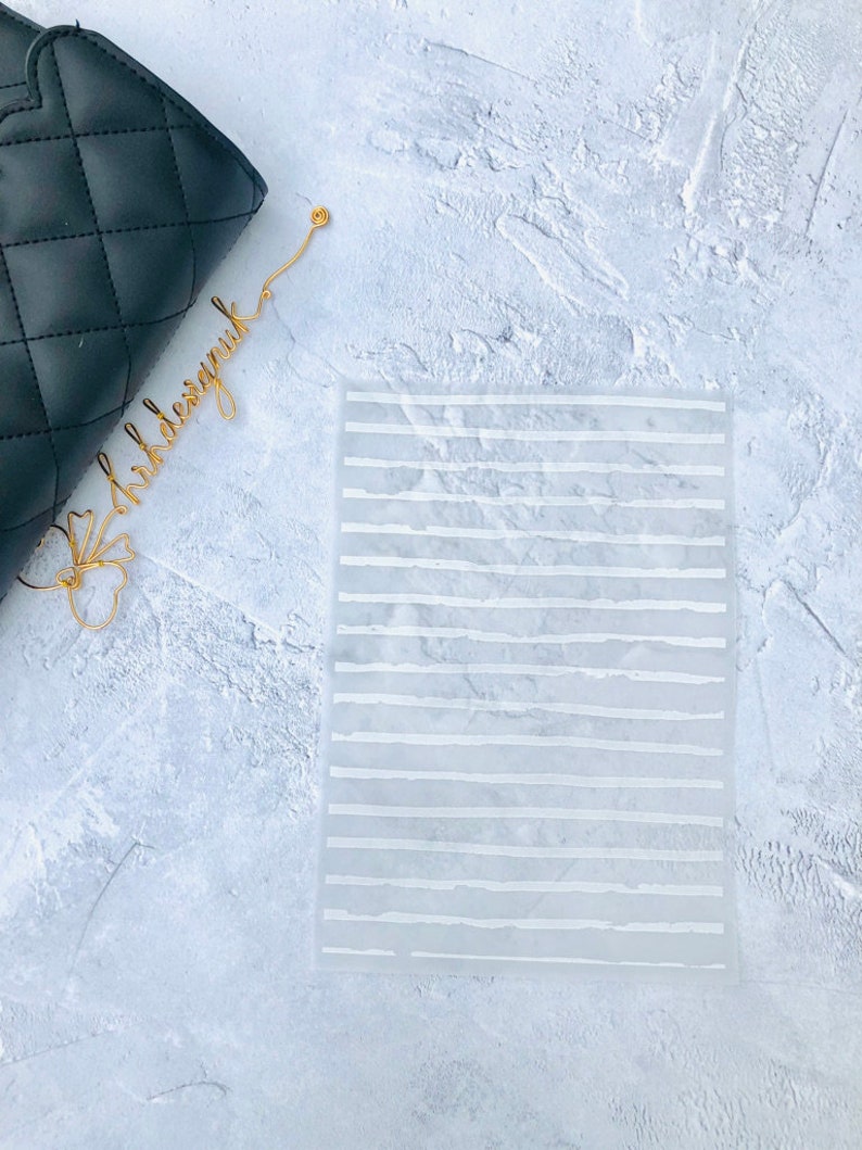 May include: A white, translucent sheet with a grid of white lines. The lines are uneven and have a slightly textured look.