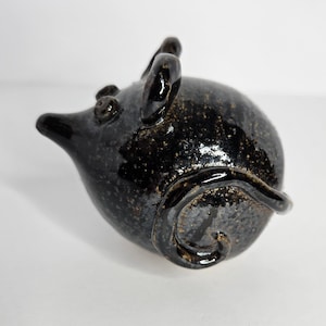 May include: A glossy black ceramic mouse figurine with gold speckles. The mouse has a long snout, small ears, and a curled tail. This decorative figurine is a unique item.