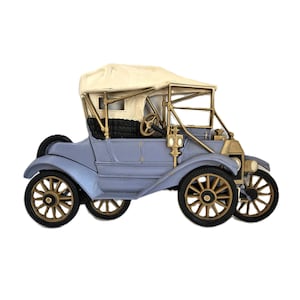 Puede incluir: Modelo de coche antiguo azul claro con techo color crema y detalles dorados. El modelo presenta ruedas, faros y volante detallados, mostrando un diseño de automóvil clásico.