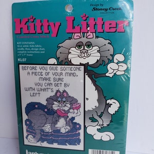 Puede incluir: Un kit de punto de cruz contado con un gato de dibujos animados con el texto "Antes de darle a alguien un pedazo de su mente, asegúrese de que puede arreglárselas con lo que queda". El kit incluye una tela Aida blanca de 14 puntos, aguja, hilo, gráfico de diseño, instrucciones y un marco de 12,7x17,8 cm. El kit es de la colección Kitty Litter de Stoney Creek.