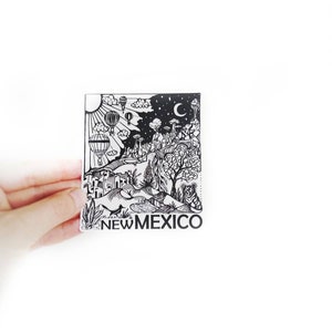 May include: Black and white illustration of a landscape with hot air balloons, a crescent moon, and the words "NEW MEXICO".