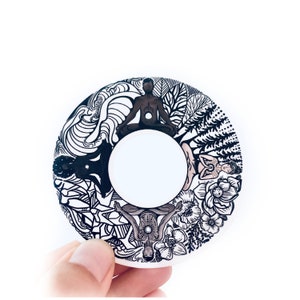 May include: Black and white circular design featuring four figures in a yoga pose, surrounded by stylized floral and wave patterns. The figures are in various poses, with one figure in the center of the circle.