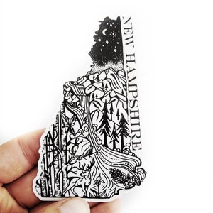 May include: Black and white line art sticker of the state of New Hampshire with a mountain scene, a river, trees, and a deer. The text "NEW HAMPSHIRE" is on the right side of the sticker.