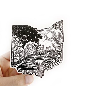 May include: Black and white illustration of the state of Ohio, filled with nature scenes, including trees, a bridge, a waterfall, deer, and a sun and moon in the sky. The word "OHIO" is written in a stylised font at the bottom right corner of the illustration.