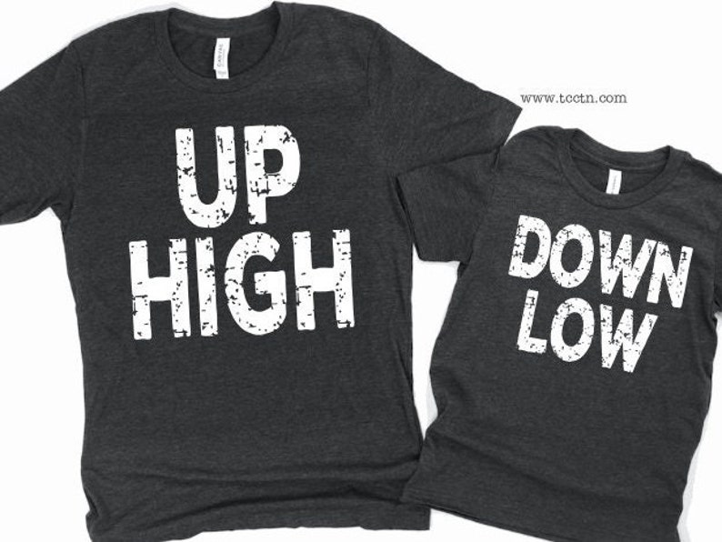 May include: Two gray t-shirts with white text. The first shirt says 'UP HIGH' and the second shirt says 'DOWN LOW'.