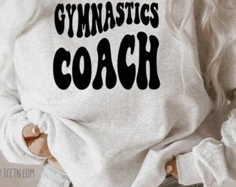 May include: A gray sweatshirt with the text "Gymnastics Coach" in black retro-style lettering.