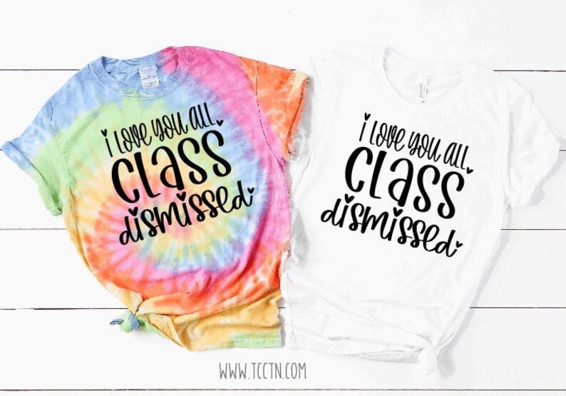 I love you all class dismissed shirt. The design features heart accents. This last day of school top for teachers is shown here on the tie dye and white top options. Both tops feature black lettering for the design.