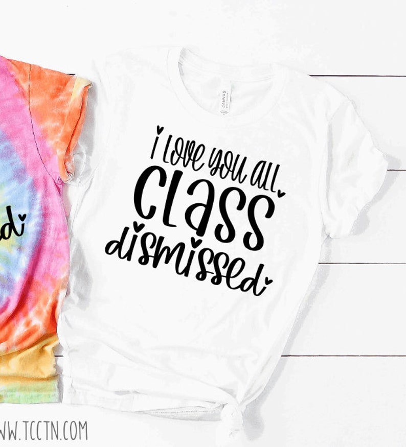 May include: White t-shirt with black text that reads "I love you all class dismissed" with hearts around the words.