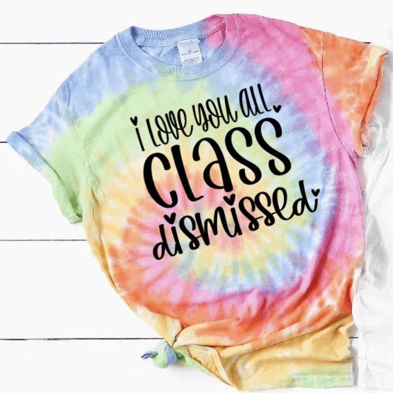 May include: A tie-dye t-shirt with the text "I love you all class dismissed" in black lettering. The shirt has a rainbow color scheme with shades of blue, green, yellow, orange, and pink.