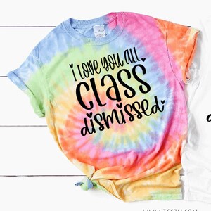 May include: A tie-dye t-shirt with the text "I love you all class dismissed" in black lettering with hearts.