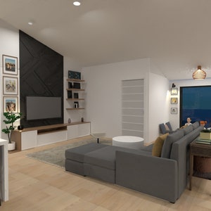 May include: A modern living room featuring a grey sectional sofa, a black entertainment unit with a TV, and a large window overlooking the ocean at night. The walls are adorned with framed pictures, and a wooden coffee table sits in the centre of the room.