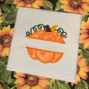 May include: A white fabric panel with an embroidered pumpkin design. The pumpkin is orange with white polka dots and has a green stem and brown stem.