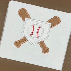 May include: White fabric with an embroidered baseball, two crossed bats, and a home plate.