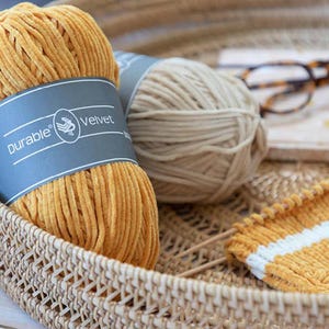 Op de afbeelding: Een witte keramische mok met een zwarte handgreep en de tekst "But First, Coffee" in een vetgedrukte, zwarte letter. De mok staat tegen een vage achtergrond, wat een gezellige setting suggereert.